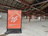 A sign saying "The Weaving Sheds" in a large venue 